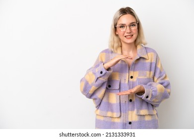 Young caucasian woman isolated on white background holding copyspace imaginary on the palm to insert an ad