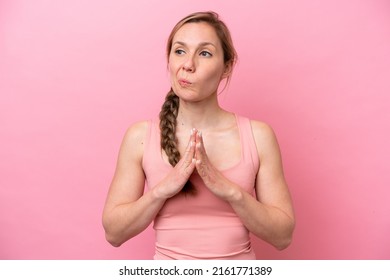 Young caucasian woman isolated on pink background scheming something