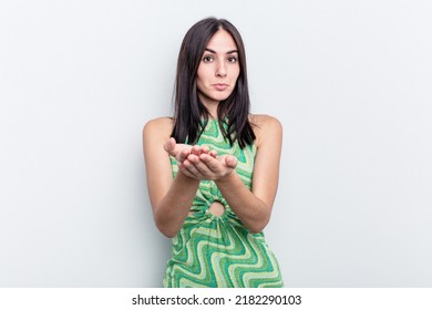 Young Caucasian Woman Isolated On White Background Holding Something With Palms, Offering To Camera.