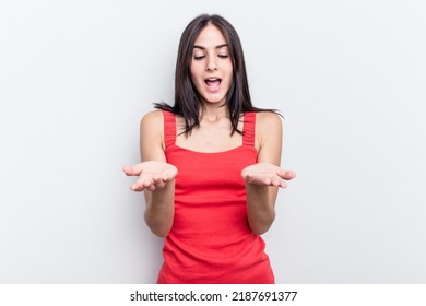 Young Caucasian Woman Isolated On White Background Holding Something With Palms, Offering To Camera.