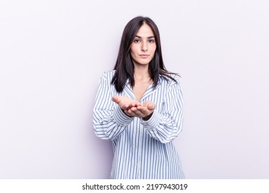 Young Caucasian Woman Isolated On Pink Background Holding Something With Palms, Offering To Camera.