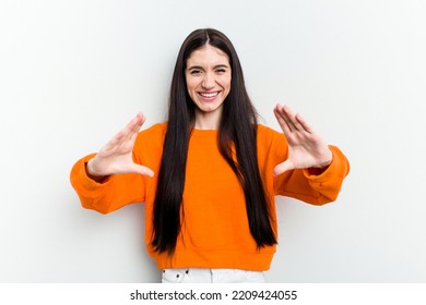 Young Caucasian Woman Isolated On White Background Holding Something With Palms, Offering To Camera.