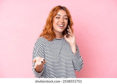 Young caucasian woman isolated on pink background keeping a conversation with the mobile phone with someone - Powered by Shutterstock