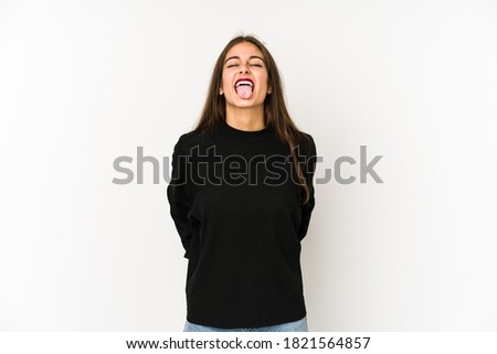 Young caucasian woman isolated on white background funny and friendly sticking out tongue.