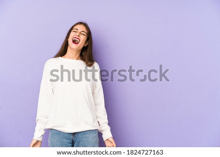 Young caucasian woman isolated on purple background relaxed and happy laughing, neck stretched showing teeth.