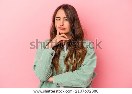 Young caucasian woman isolated on pink background unhappy looking in camera with sarcastic expression.