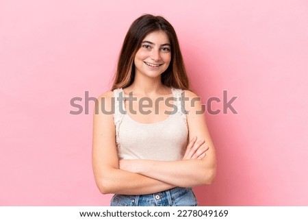 Young caucasian woman isolated on pink background keeping the arms crossed in frontal position
