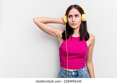 Young Caucasian Woman Listening To Music Isolated On White Background Touching Back Of Head, Thinking And Making A Choice.