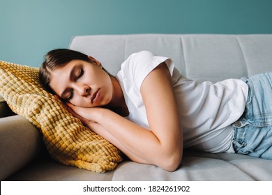 Young caucasian woman lying on sofa in living room sleeping after hard-working day, tired millennial female fall asleep on couch at home, take nap or daydream, fatigue concept - Powered by Shutterstock