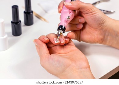 Young Caucasian Woman Making Self Manicure At Home With The Help Of Electrical Fraser Machine And Other Tools For Nail Procedures