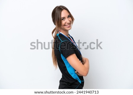 Young caucasian woman with medals isolated on white background with arms crossed and looking forward