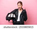 Young caucasian woman with a motorcycle helmet isolated on pink background thinking an idea pointing the finger up