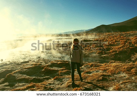 young caucasian woman near Geyser (geothermal area) in morning, Bolivia