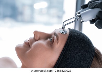 Young caucasian woman on microcurrent therapy procedure. Beautician's office. - Shutterstock ID 2368829023