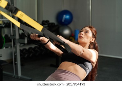 Young Caucasian Woman Performing A Trx Low Row At The Gym