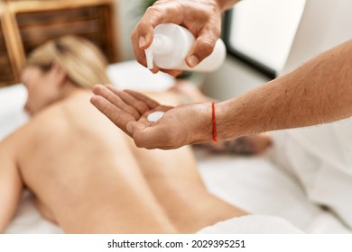 Young caucasian woman at physiotherapy clinic getting muscle massage by professional therapist. Physiotherapist man doing rehabilitation treatment to client - Powered by Shutterstock