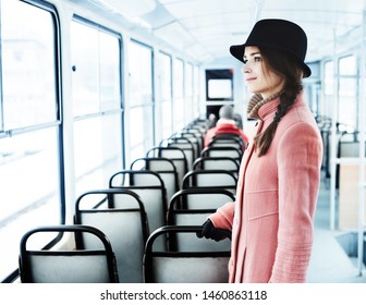 Young caucasian woman in a pink coat and hat is a passenger in public transport. - Shutterstock ID 1460863118