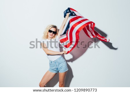 young caucasian woman posing and waving USA flag, Independence Day Celebration