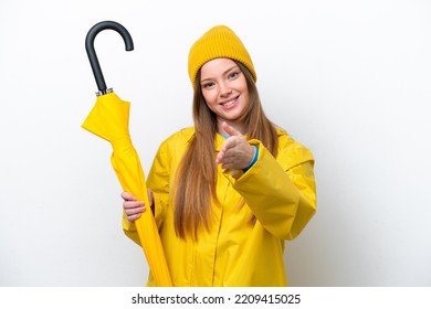 Young caucasian woman with rainproof coat and umbrella isolated on white background shaking hands for closing a good deal - Shutterstock ID 2209415025
