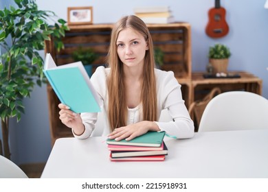 Young Caucasian Woman Reading Books At Home Thinking Attitude And Sober Expression Looking Self Confident 