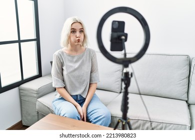 Young Caucasian Woman Recording Vlog Tutorial With Smartphone At Home Puffing Cheeks With Funny Face. Mouth Inflated With Air, Crazy Expression. 