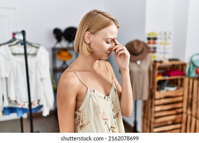 Young caucasian woman at retail shop tired rubbing nose and eyes feeling fatigue and headache. stress and frustration concept. 