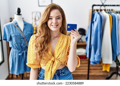 Young caucasian woman at retail shop holding credit card looking positive and happy standing and smiling with a confident smile showing teeth  - Shutterstock ID 2230584889