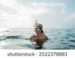 Young caucasian woman with scuba diving mask swimming in the sea during the day