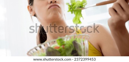 Young caucasian woman sitting on sofa eating vegetable salad while feeling dislike and expression disgusted, woman emotion frustrated with anorexia vegetarian and hate, nutrition food concept.