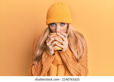 Young Caucasian Woman Smelling Coffee Aroma Over Yellow Background