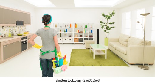 young caucasian woman standing in clean house holding cleaning products, looking at tidy room