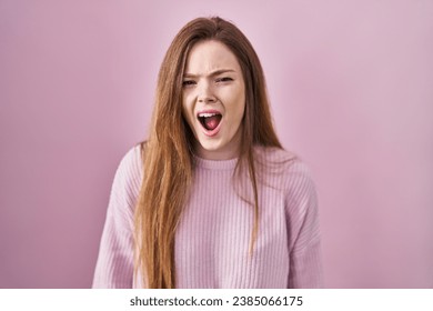 Young caucasian woman standing over pink background angry and mad screaming frustrated and furious, shouting with anger. rage and aggressive concept.  - Shutterstock ID 2385066175