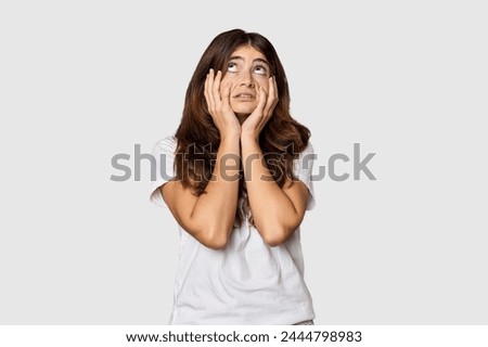 Young Caucasian woman in studio setting whining and crying disconsolately.