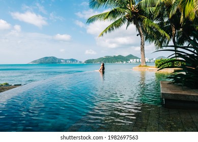 Young Caucasian Woman In Swimming Pool On Beautiful Tropical Bay, Blue Sky And Ocean, Summer Vacation Concept.