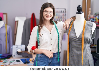 Young caucasian woman tailor smiling confident leaning on manikin at tailor shop - Shutterstock ID 2256913373