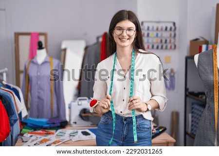Young caucasian woman tailor smiling confident standing at tailor shop