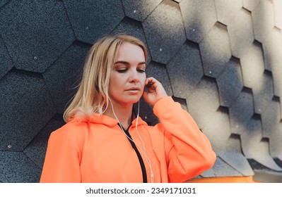 Young caucasian woman taking breath after jogging. Female athlete resting with hands on knees and looking away over grey background - Powered by Shutterstock