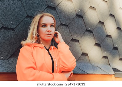 Young caucasian woman taking breath after jogging. Female athlete resting with hands on knees and looking away over grey background - Powered by Shutterstock