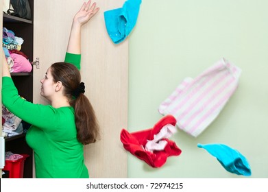 Young Caucasian Woman Throwing A Clothes From The Wardrobe Back.