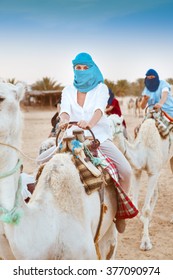 Young Caucasian Woman Tourist Riding On Camel In Sahara Desert. Tunis