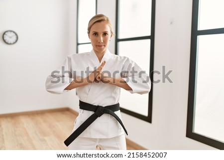 Young caucasian woman training karate at sport center