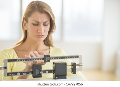 Young Caucasian Woman Using Balance Weight Scale At Gym