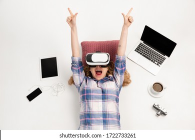 Young caucasian woman using devices, gadgets isolated on white studio background. Concept of modern technologies, gadgets, tech, emotions, ad. Copyspace. Gaming, shopping, meeting online education.