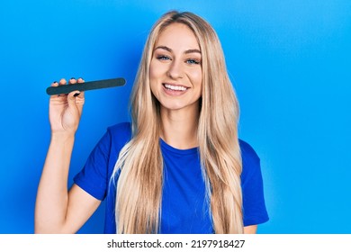 Young Caucasian Woman Using File Nail Looking Positive And Happy Standing And Smiling With A Confident Smile Showing Teeth 