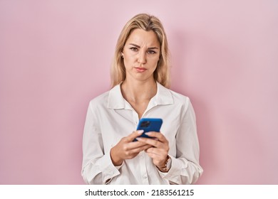 Young Caucasian Woman Using Smartphone Typing Message Depressed And Worry For Distress, Crying Angry And Afraid. Sad Expression. 