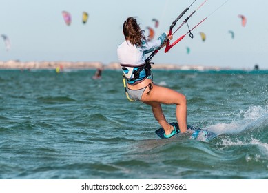 Young caucasian woman wearing bikini swimwear kite-surfing in El Gouna, Egypt, beautiful girl kitesurf in Hurgada