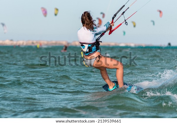 Young caucasian\
woman wearing bikini swimwear kite-surfing in El Gouna, Egypt,\
beautiful girl kitesurf in\
Hurgada