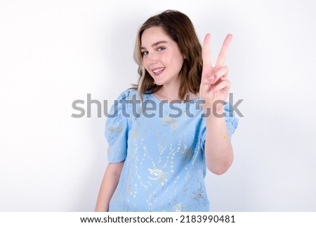 young caucasian woman wearing blue T-shirt over white background directs fingers at camera selects someone. I recommend you. Best choice