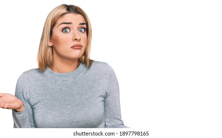 Young caucasian woman wearing casual clothes clueless and confused expression with arms and hands raised. doubt concept.  - Shutterstock ID 1897798165