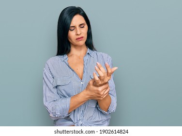 Young caucasian woman wearing casual clothes suffering pain on hands and fingers, arthritis inflammation 